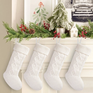 Close-up of four white cable knit Christmas stockings hanging on a festive fireplace mantel
