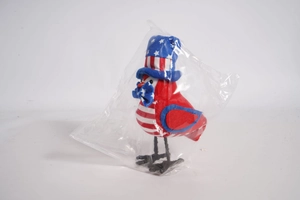 Detail of Independence Day bird figurine with US flag hat and blue bow in packaging