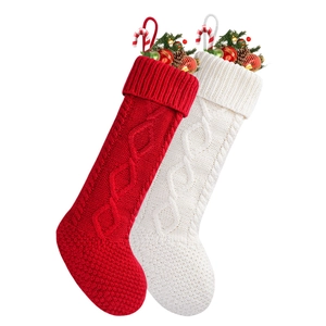 Large knitted Christmas stockings in red and white with pine cones and candy canes
