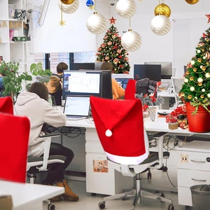 Red Christmas hat chair cover with white plush ball decoration for festive dining decor