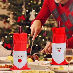 Festive Santa Claus drawstring wine bottle bags set on a cozy Christmas dining table