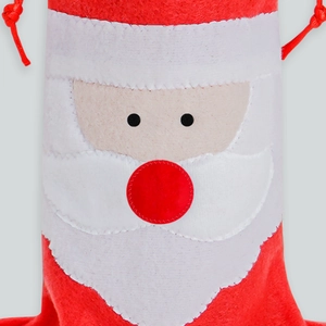 Detail of felt Santa Claus drawstring bag with white beard for Christmas gift packaging