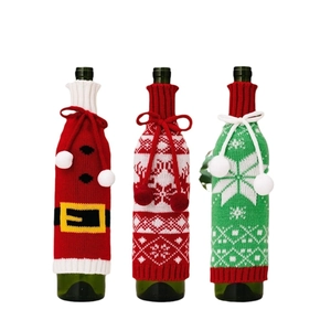 Three styles of knitted Christmas wine bottle covers with snowflakes and pom-pom ties