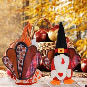 Detail of Thanksgiving gnomes with turkey feathers and maple leaves on a hay background