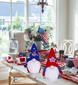 Patriotic USA gnome plush figurines on wooden table with Fourth of July decor accents