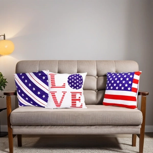 Three USA flag theme pillows with stars stripes and LOVE print on a cozy sofa