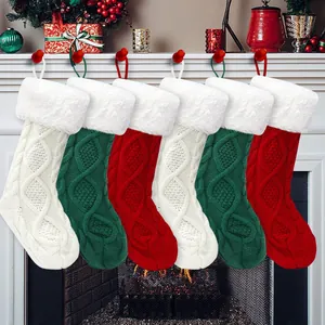 Detail of cable knit Christmas stockings with plush faux fur cuffs hung on a fireplace