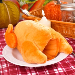 Close-up of plush turkey wine bottle cover with soft texture on festive plaid background