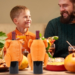 Detail of plush turkey wine bottle covers for Thanksgiving tabletop decor in a warm home setting