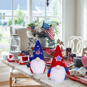Set of two Independence Day gnomes with red and blue star hats on a wooden desk