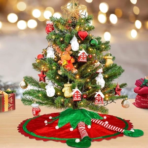 Detail of red and green velvet Christmas tree skirt with striped elf legs and shoes