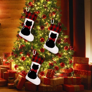 Detailed view of red black plaid Christmas stockings with black cat silhouette on a tree