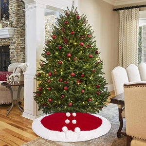 Dettaglio della gonna per albero di Natale rossa in maglia con bordo in peluche e pompon