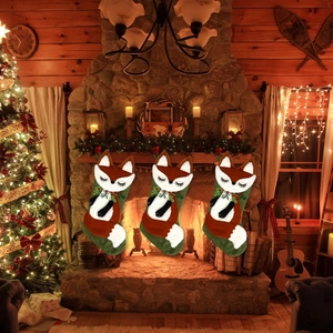 Trois chaussettes de Noël en peluche renard avec broderies et baies de fête rouges