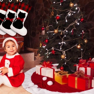Dettaglio di tre calze di Natale trapuntate bianche con gatto nero e risvolto a quadretti