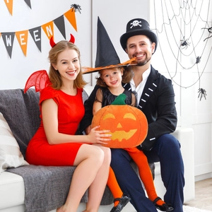 Orange pumpkin shaped plush pillow with Halloween themed family party decorations