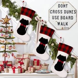 Three-piece quilted dog Christmas stockings with red buffalo plaid hung on stair rails