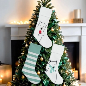 Detailansicht von drei dekorativen Weihnachtssocken, die an einem beleuchteten Baum hängen