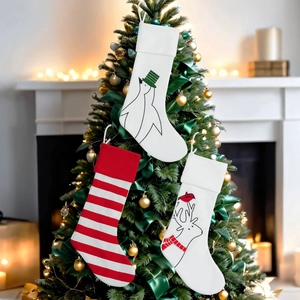 Drei Weihnachtssocken mit Pinguin- und Rentier-Mustern am Weihnachtsbaum hängend
