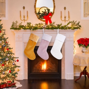 Plush Christmas stockings in yellow, purple and white hanging on fireplace mantel