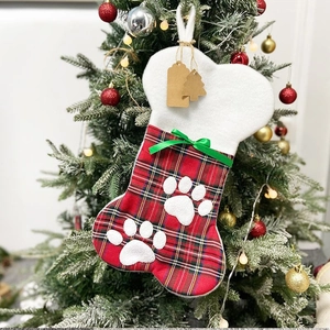 Dettaglio calza di Natale a forma di osso con impronte di zampe appesa all'albero festivo