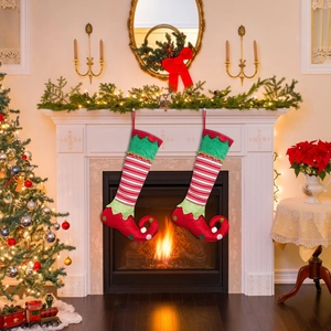 Detail of red and white striped elf Christmas stockings hanging on a white fireplace