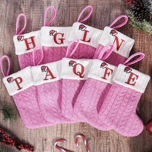 Rosa Strick-Weihnachtssocken mit roten Buchstaben-Stickereien und Mini-Weihnachtsmann-Hüten