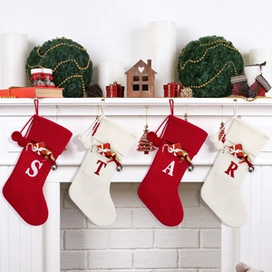Close-up of knit Christmas stockings with STAR letters hanging on a white fireplace