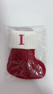 Macro shot of red knit Christmas stocking with white cuff and letter I embroidery