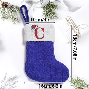 Detail view of royal blue knit Christmas stocking with white cuff and red letter C embroidery