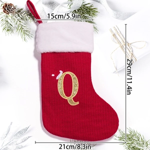 Detail showing red knitted Christmas stocking with white faux fur and golden letter Q embroidery