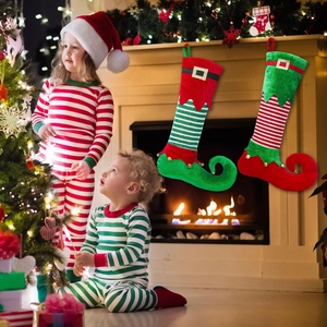 Detail of Christmas elf stockings with bells and gold buckles on a holiday fireplace