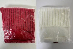 Detail of red and ivory chunky cable knit Christmas stockings in protective packaging