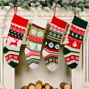 Detailed knit texture of four Christmas stockings featuring reindeer and snowman patterns
