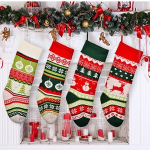 Set of 4 festive knitted Christmas stockings with reindeer and snowman on a white fireplace