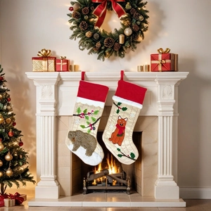 Detail von bestickten Weihnachtsstrümpfen mit Bären- und Fuchsmotiven am Kamin