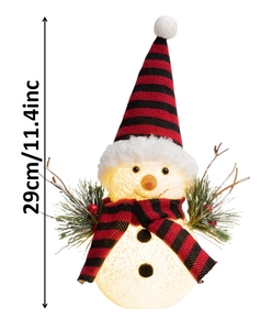 Detail of glowing Christmas snowman with LED lights, red plaid hat and berry branches