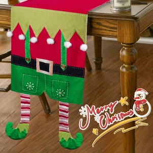 Christmas elf table runner with red green stripes and pom-poms on dark wood table