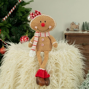 Plush Christmas gingerbread man doll with bow and striped scarf on white faux fur base