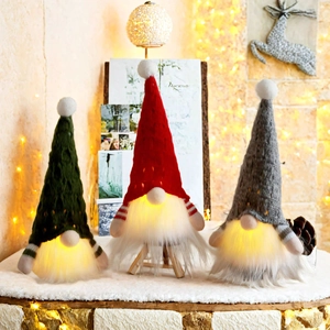 Three glowing Christmas gnomes with knitted hats and warm LED lights for holiday decor