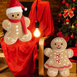 Plush gingerbread man and girl pillows with Christmas scarves in festive holiday setting