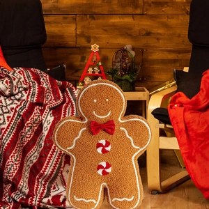 Plush gingerbread man throw pillow made of soft sherpa fabric with festive Christmas bow