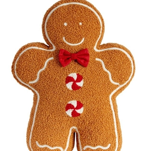 Plush gingerbread man pillow with sherpa fabric and festive red bow on white background