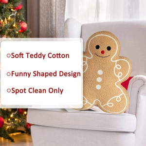 Detail of soft teddy cotton gingerbread man pillow with festive Christmas tree background