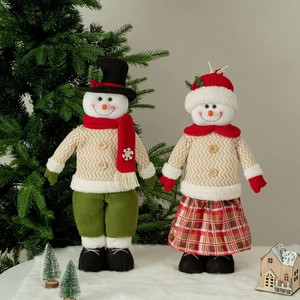 Set of two telescopic Christmas snowman dolls in knitted outfits on soft white rug
