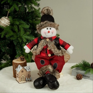 Detail of Christmas snowman plush doll with knit hat and red plaid vest on wooden base