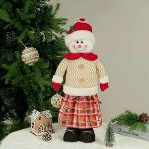Detail of Christmas snowman plush with knit sweater and plaid skirt in festive decor