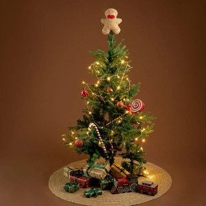 Gingerbread man Christmas tree topper with red bowtie and festive holiday lighting details