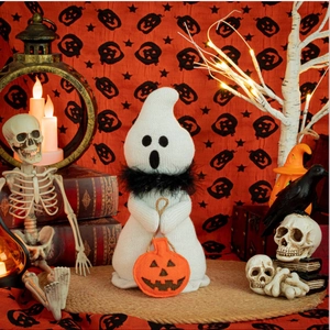 Close-up of knit Halloween ghost plush toy with scarf and pumpkin bag detail