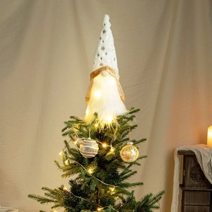 Close-up of lighted Christmas gnome tree topper with white beard and gold snowflake hat
